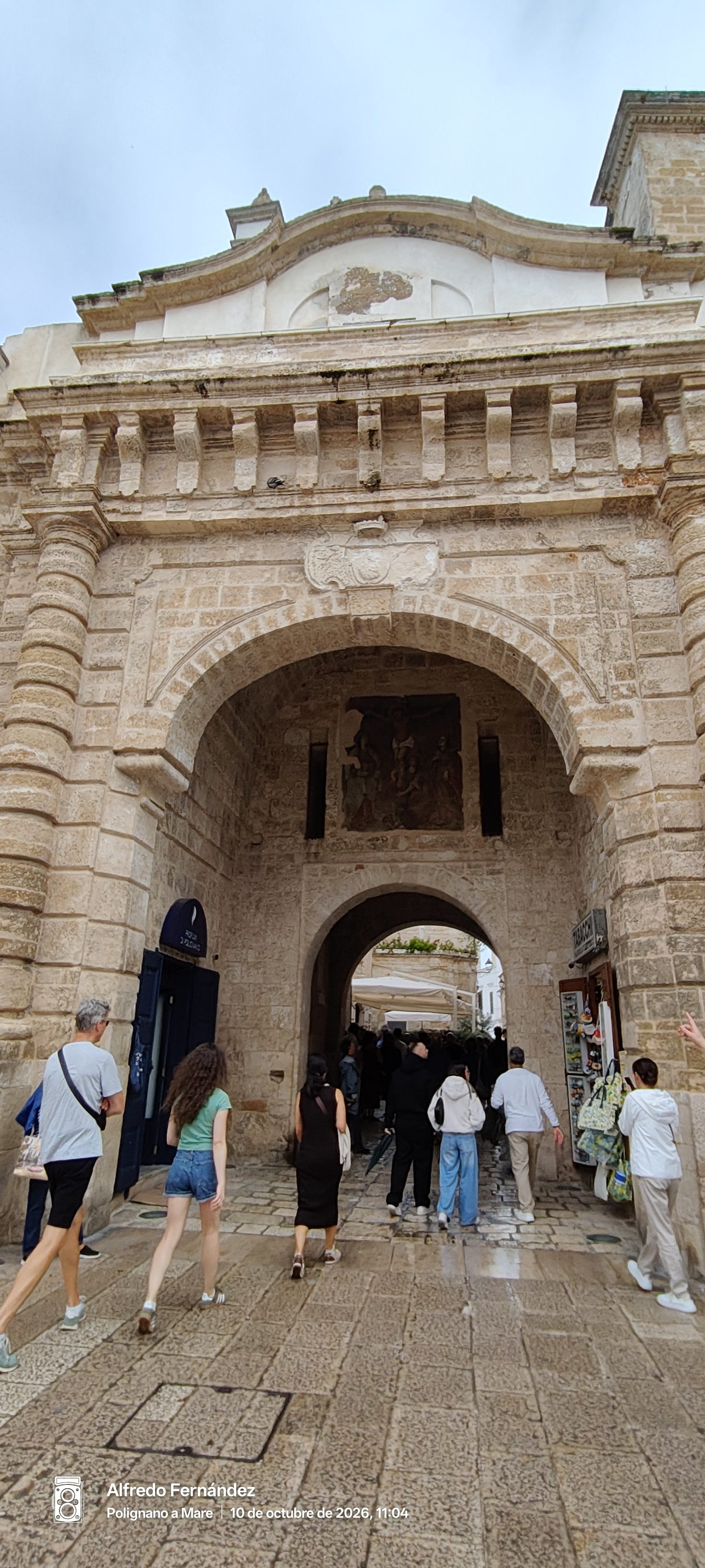 Arco Marchesale de piedra con peatones entrando al casco antiguo de la ciudad.