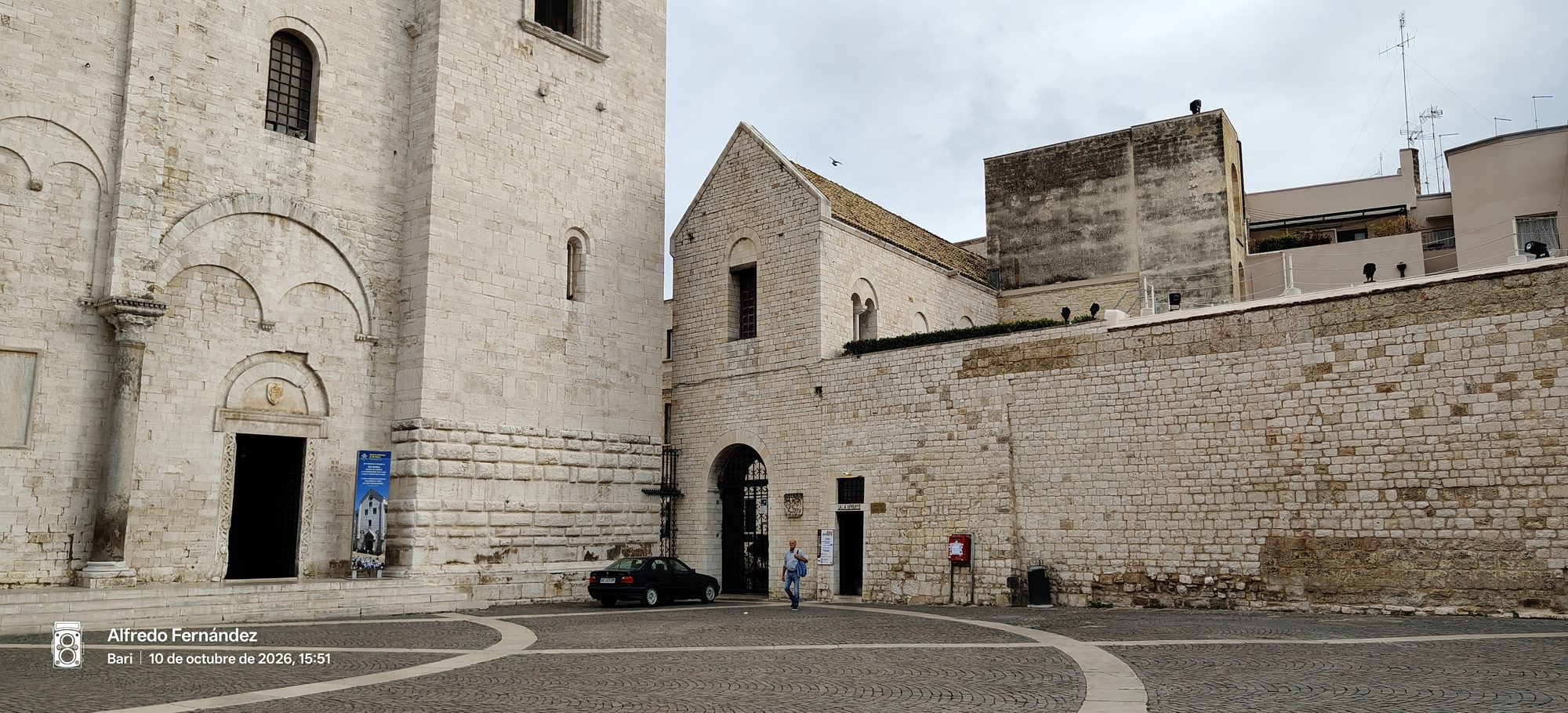 Fachada de piedra caliza y plaza adoquinada junto a la Basílica de San Nicolás en Bari.