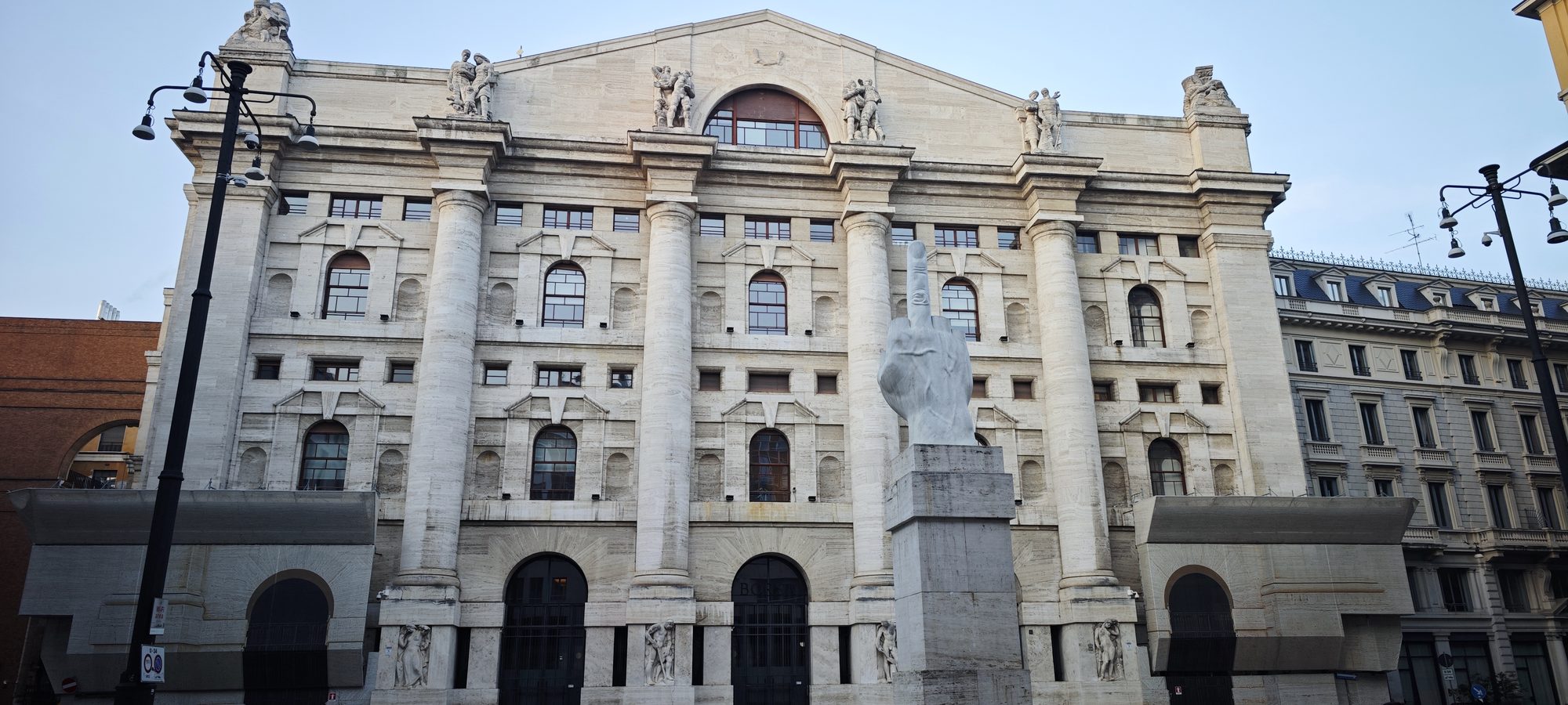 Escultura de mano de mármol con el dedo medio frente al Palacio Mezzanotte en Milán.