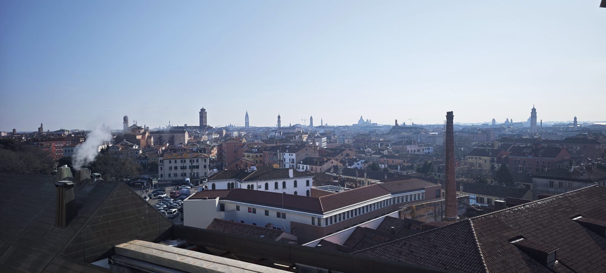 Vista panorámica de los tejados y campanarios de Venecia bajo un cielo despejado.
