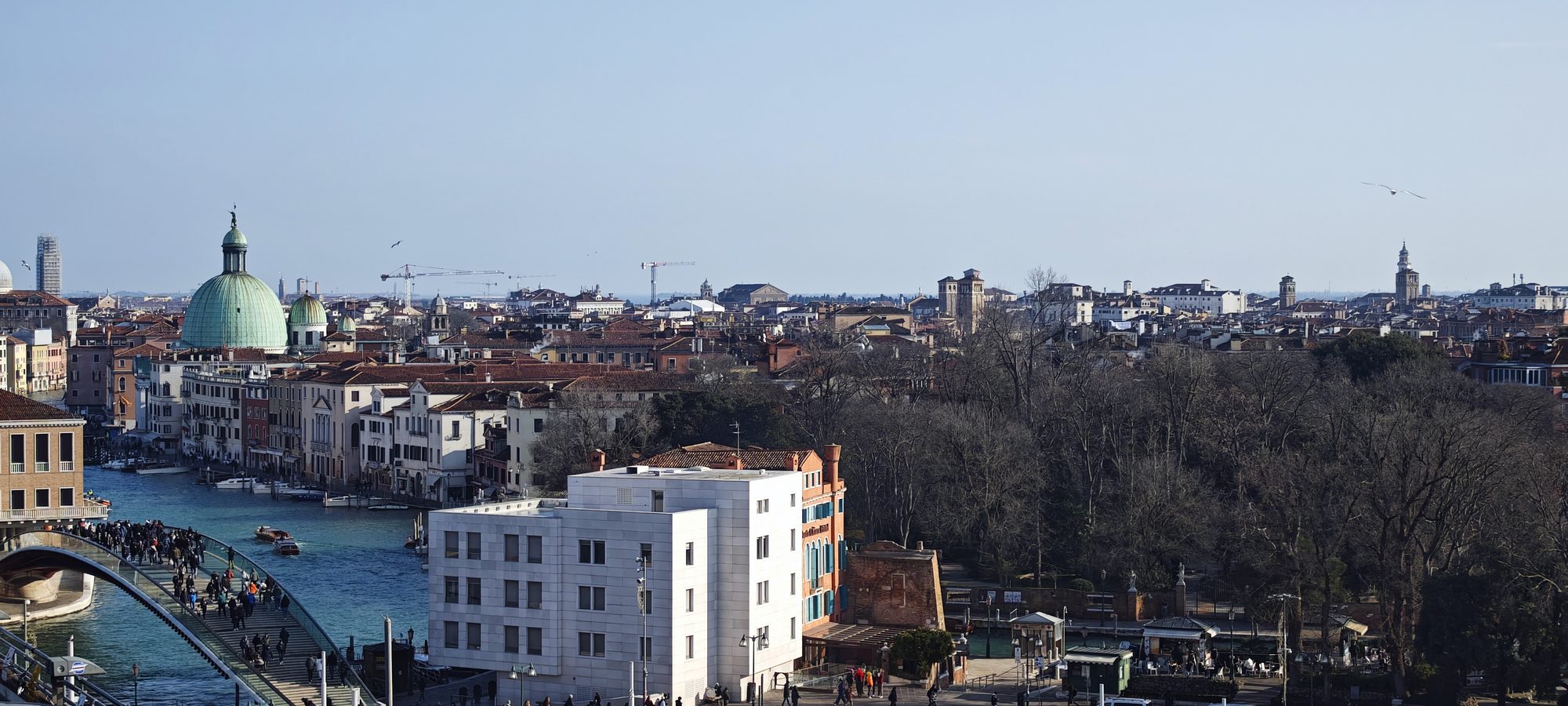Vista panorámica de los tejados y el Gran Canal de Venecia bajo un cielo despejado.