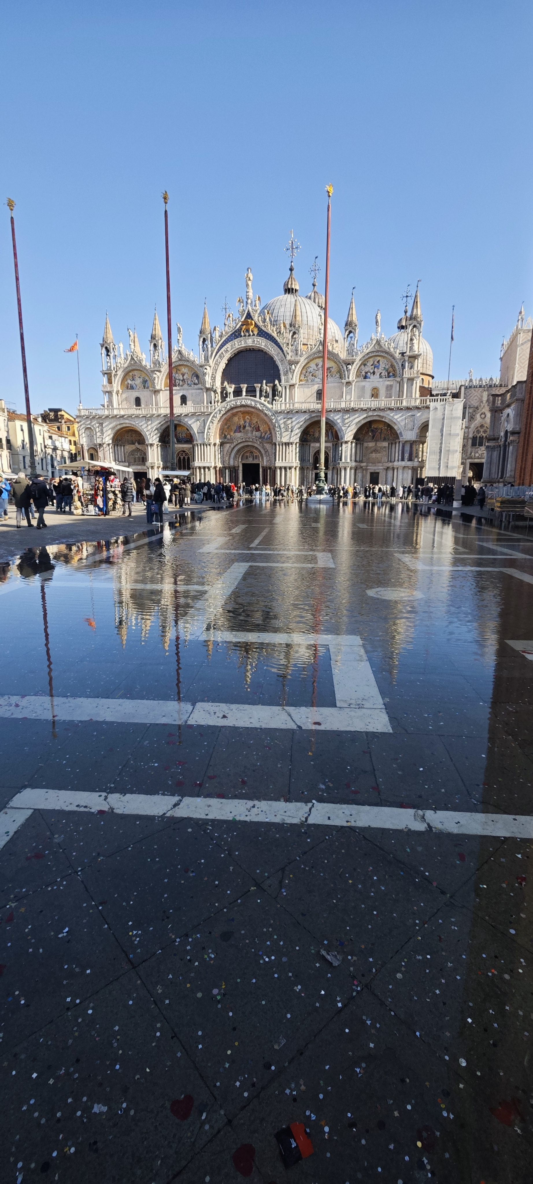 Basílica de San Marcos en Venecia reflejada sobre el agua en la plaza.