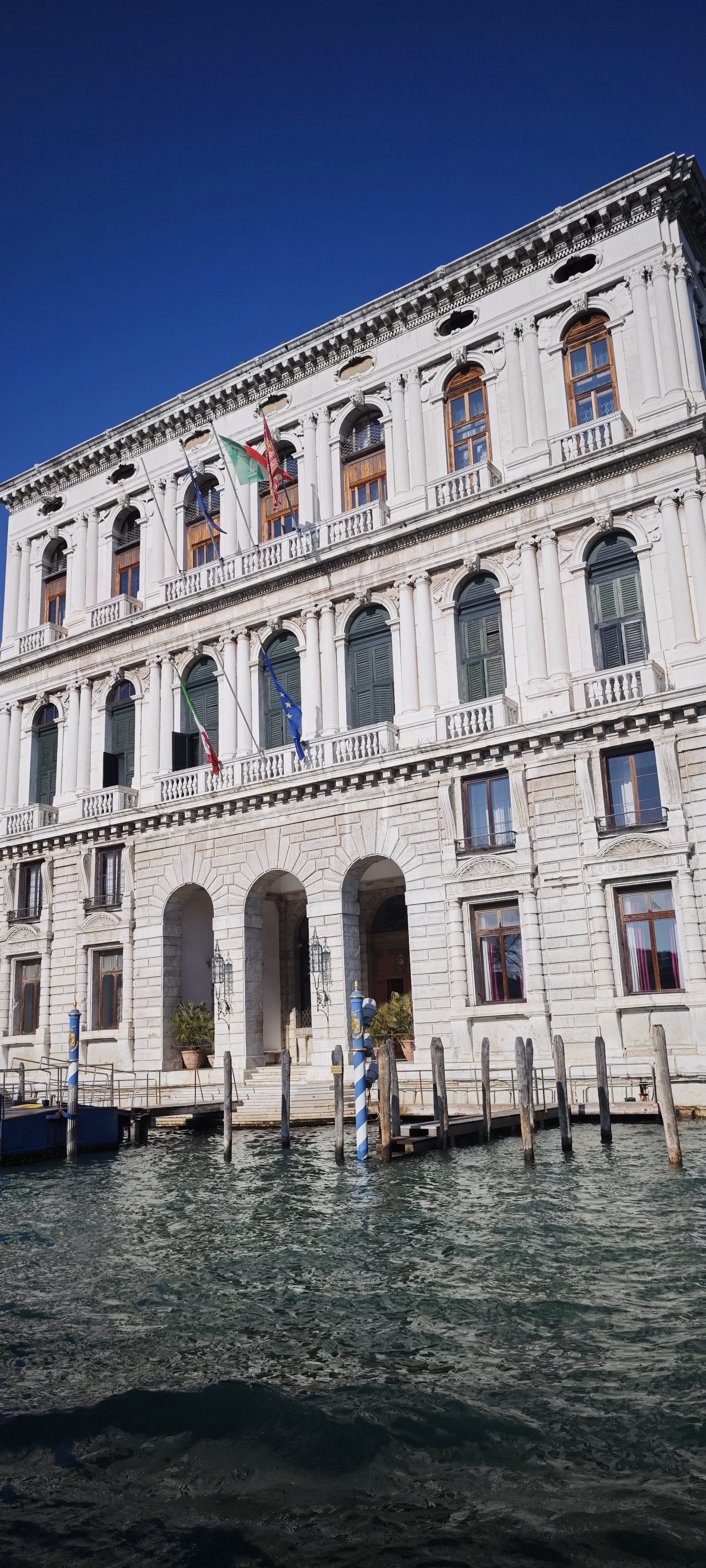 Fachada de un palacio histórico en Venecia junto a las aguas del Gran Canal.