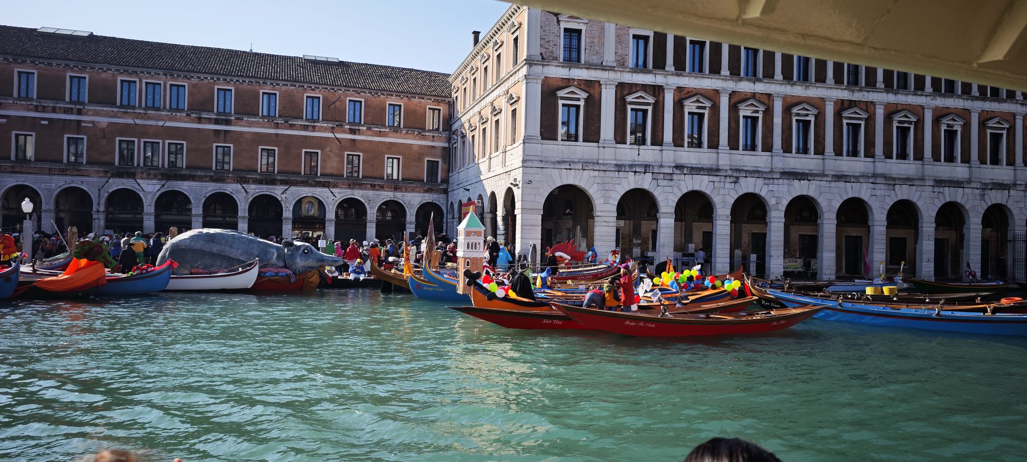 Barcas tradicionales decoradas navegando por el Gran Canal de Venecia junto a fachadas históricas.