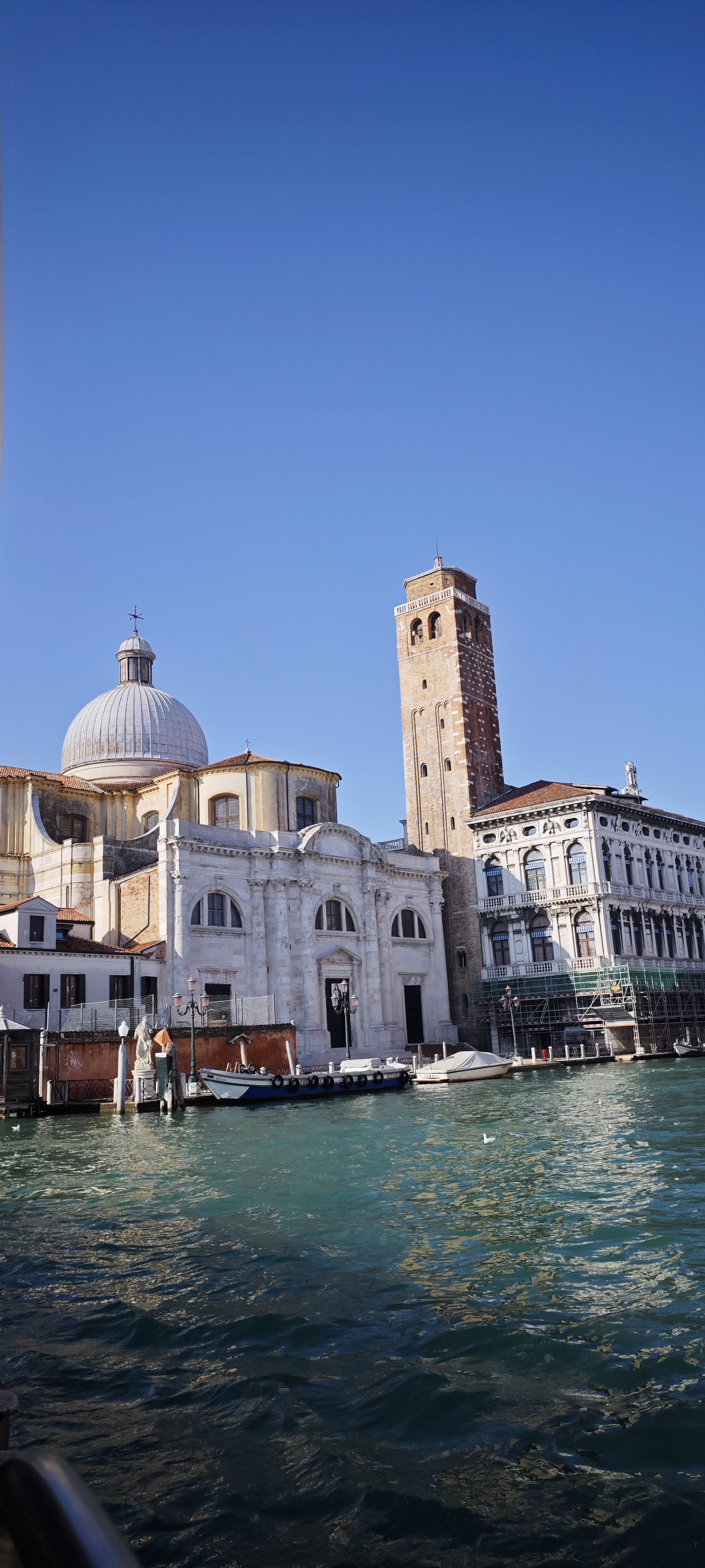 Iglesia con cúpula y campanario de ladrillo junto al Gran Canal en Venecia.