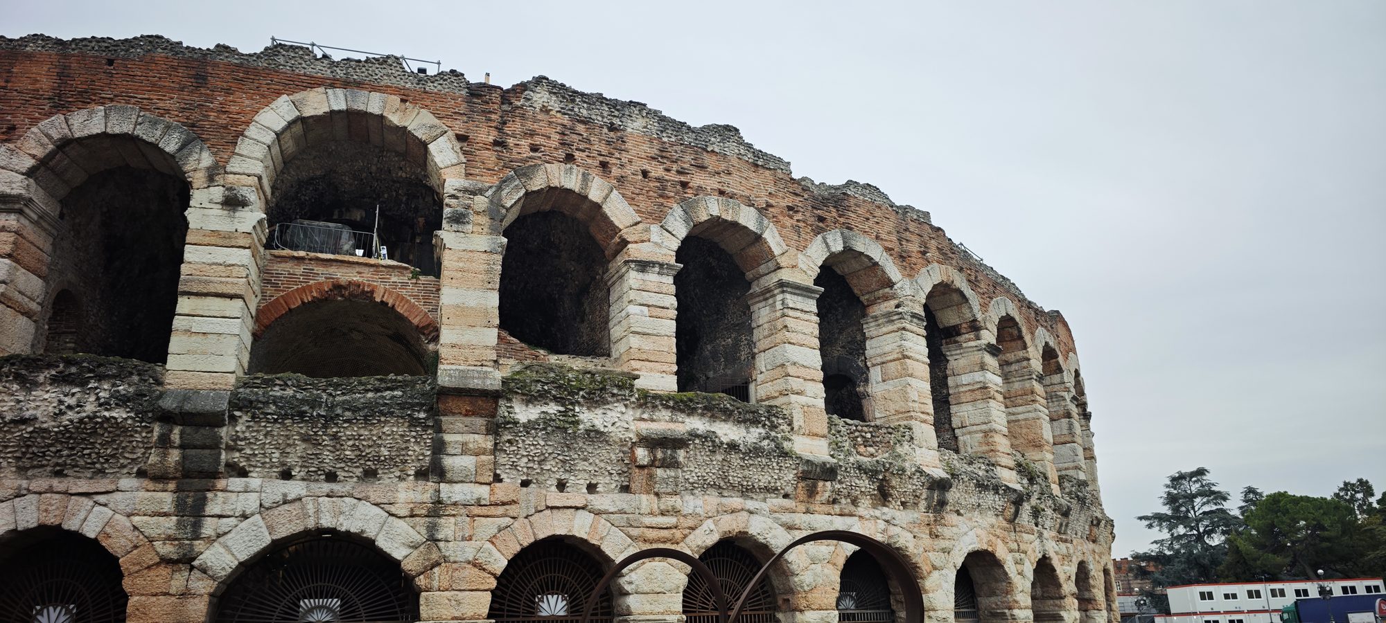 Fachada exterior de piedra y ladrillo del antiguo anfiteatro de la Arena de Verona.