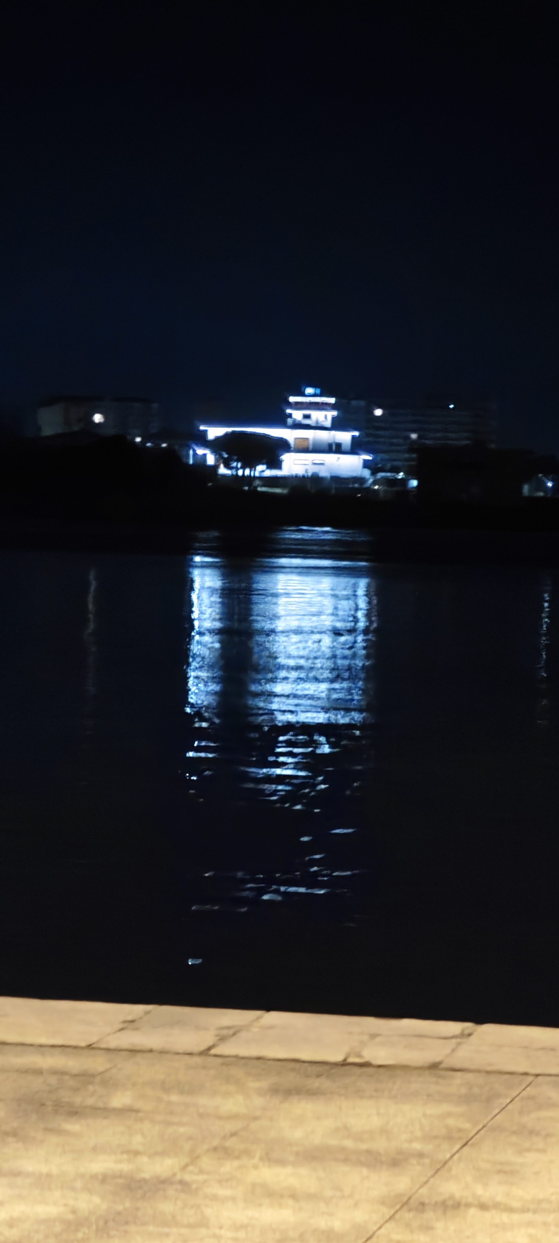 Edificio iluminado de noche reflejado en las aguas de Santoña.
