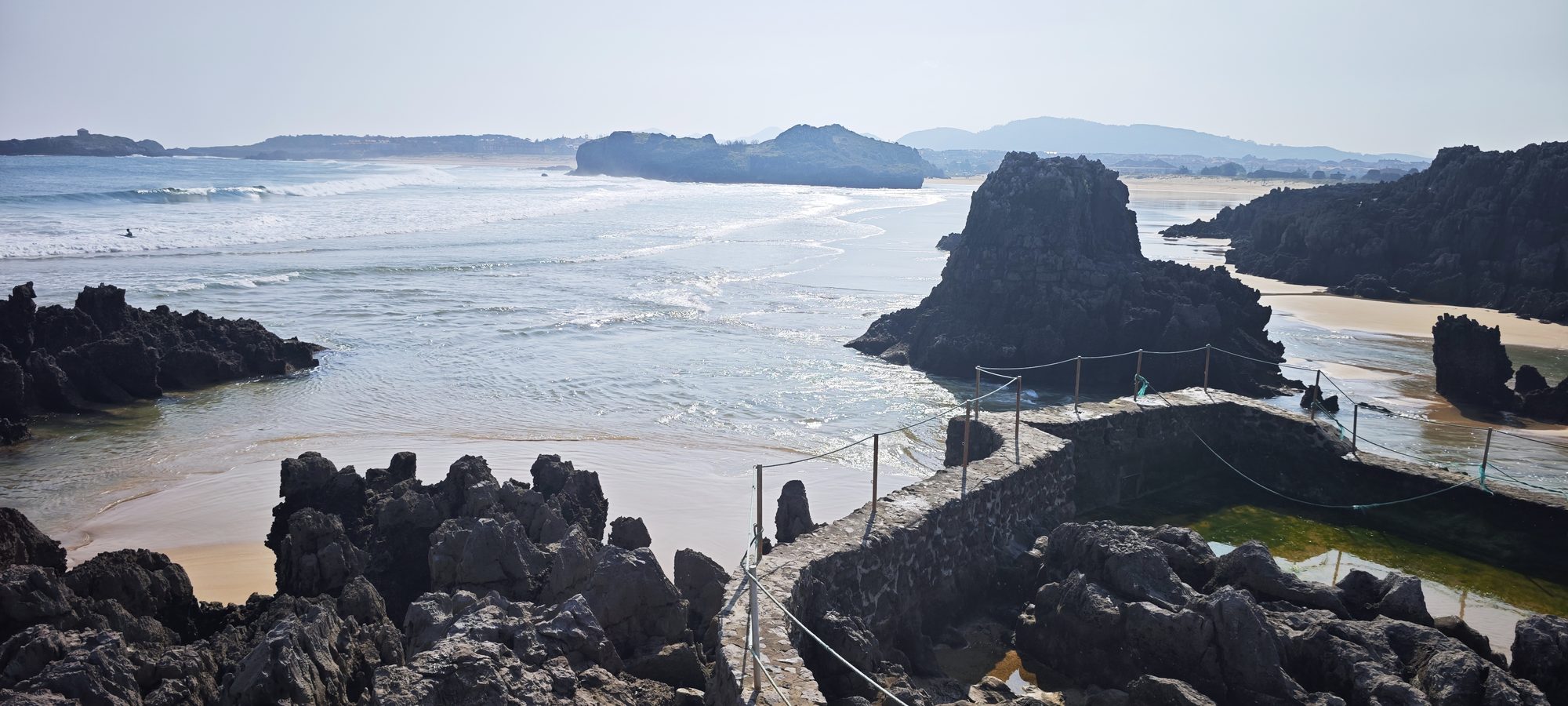 Pasarela de piedra entre rocas frente a la playa y el mar en Noja.
