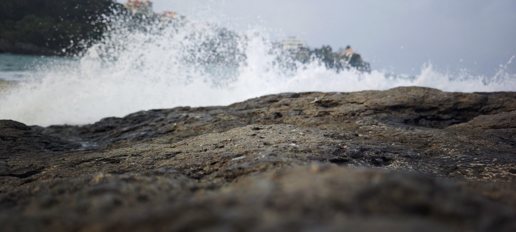 Olas del mar rompiendo con fuerza sobre rocas oscuras en la costa de España.