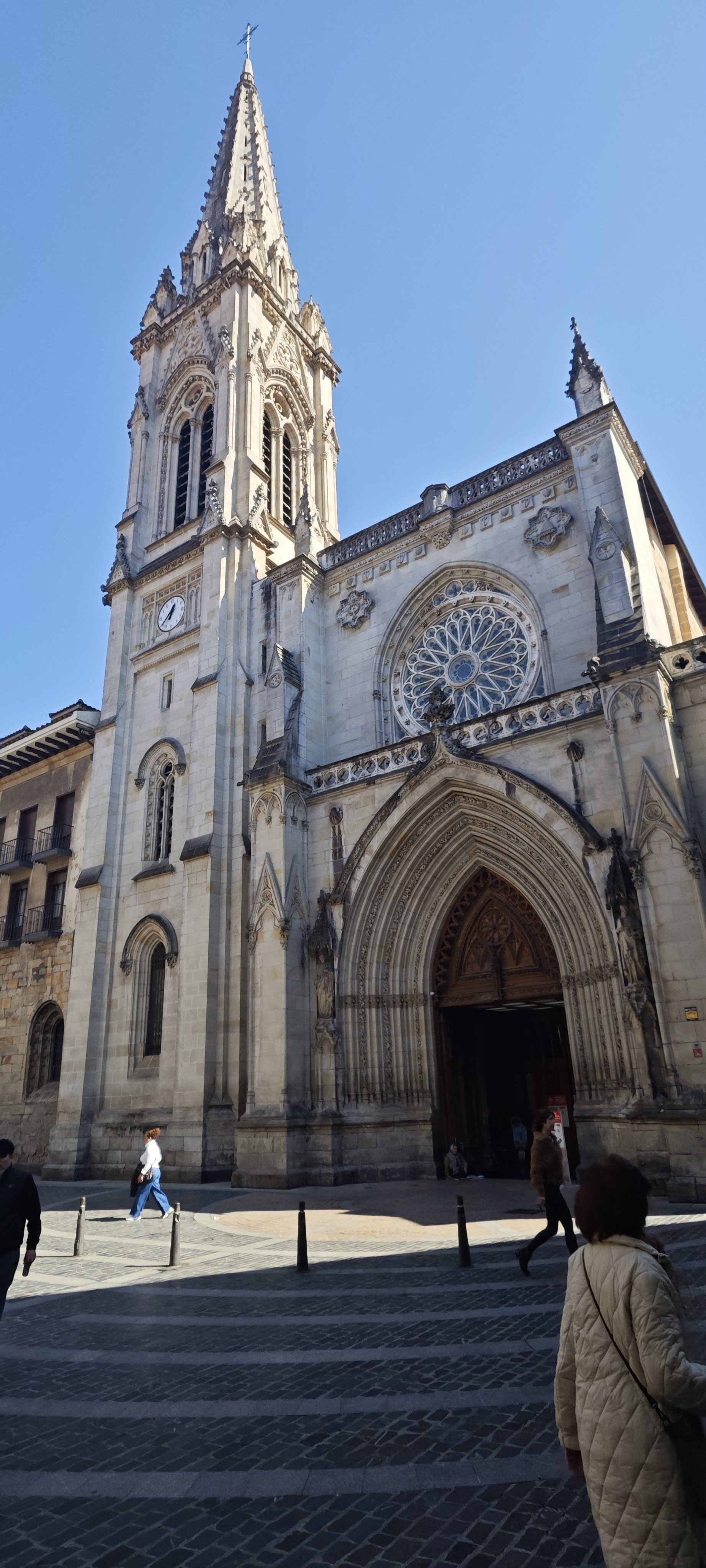 Imponente fachada y torre de la Catedral de Santiago de Bilbao bajo un cielo despejado.