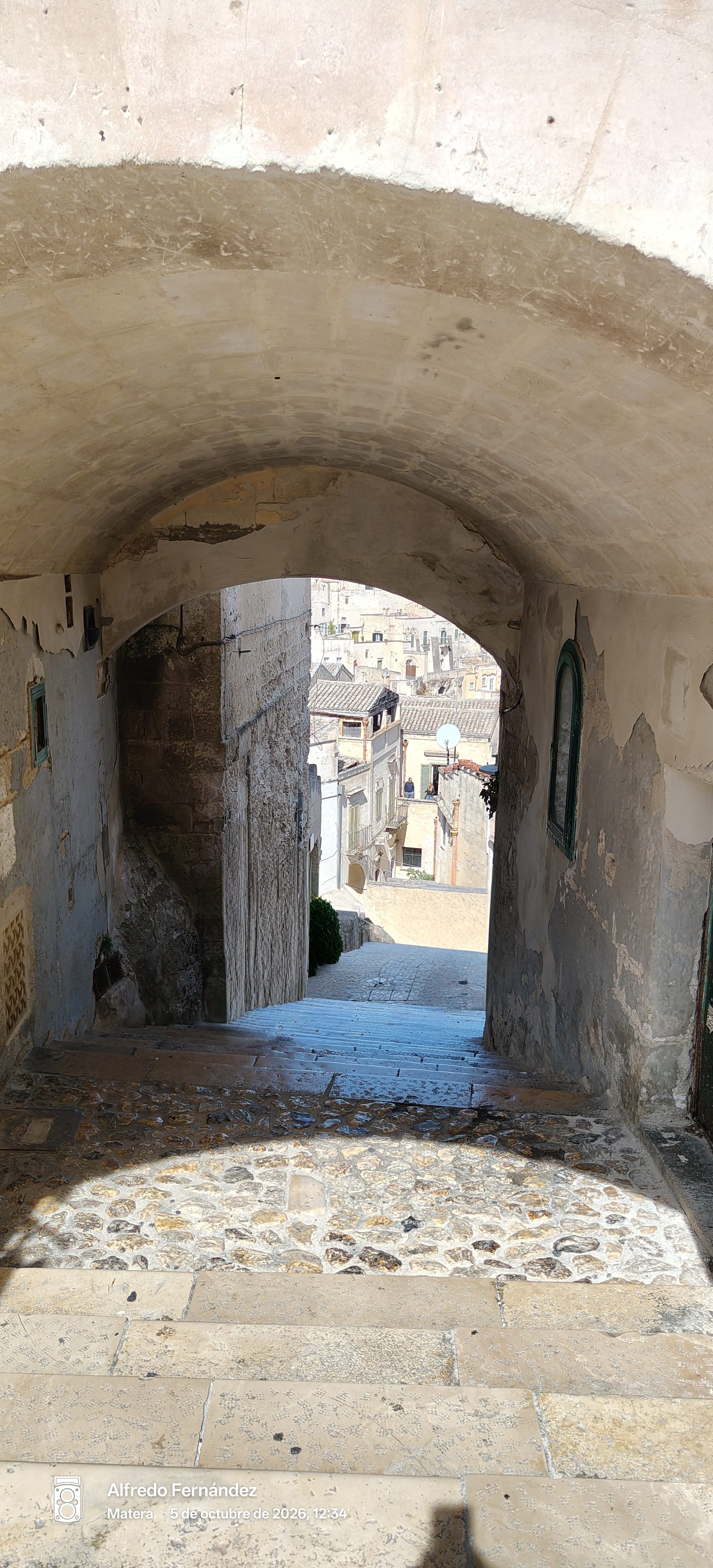 Vista de las calles de piedra de Matera a través de un arco antiguo.